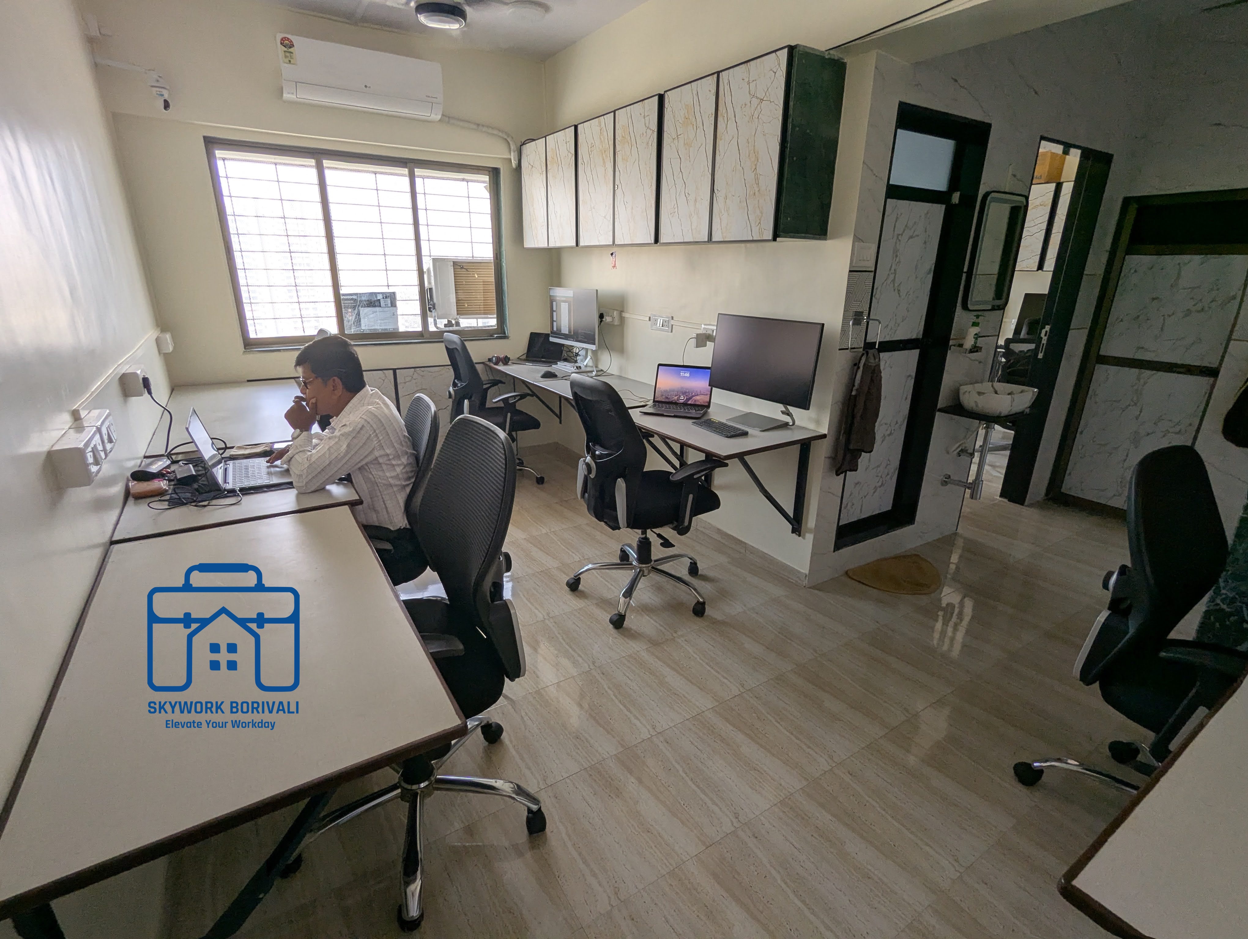 Open workspace with a member working by the window