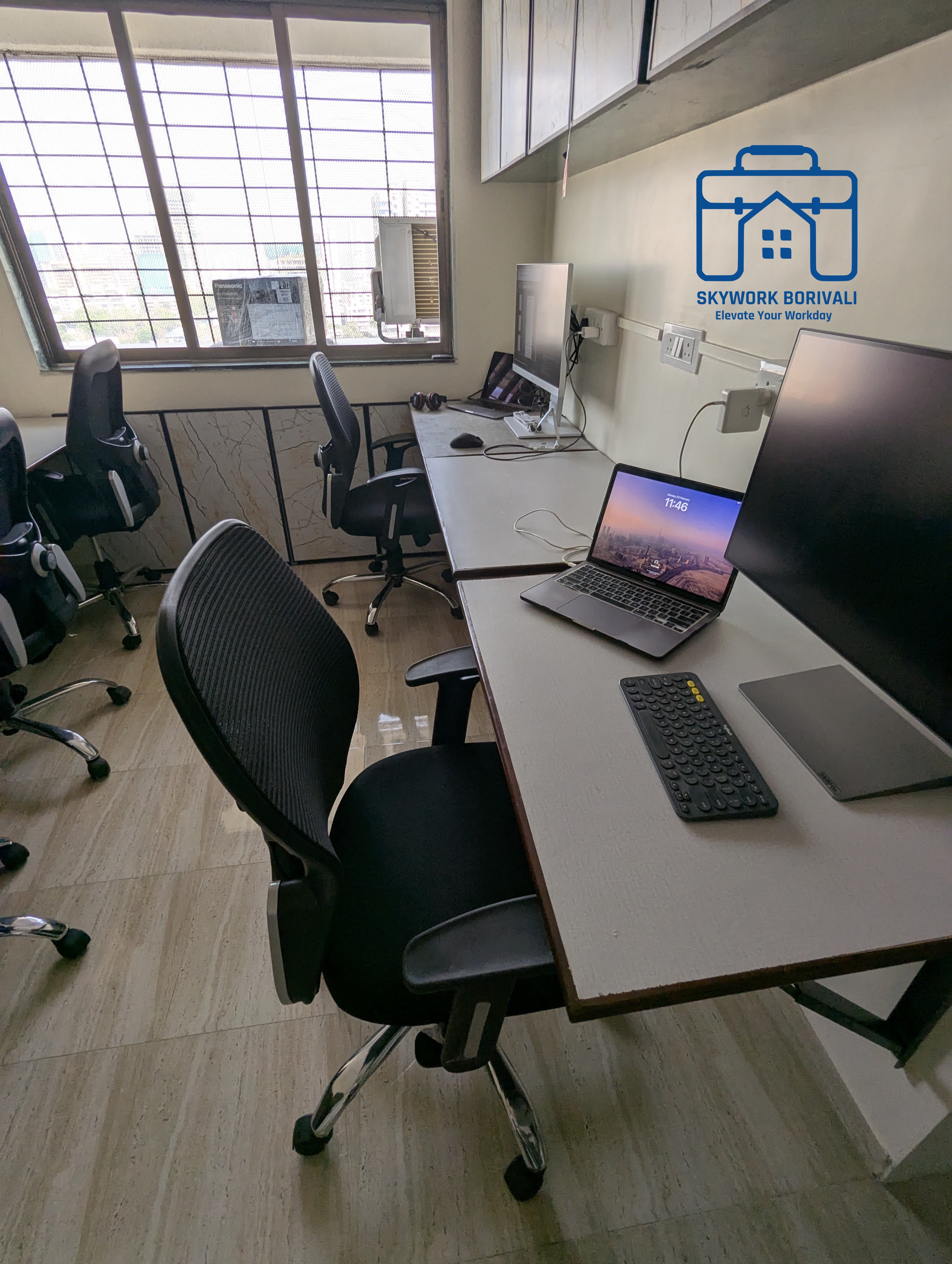 Dedicated desk with laptop and external monitor by the window